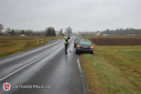 bendras vaizdas eismo įvykio vietoje su policijos pareigūnais ir sugadintais automobiliais