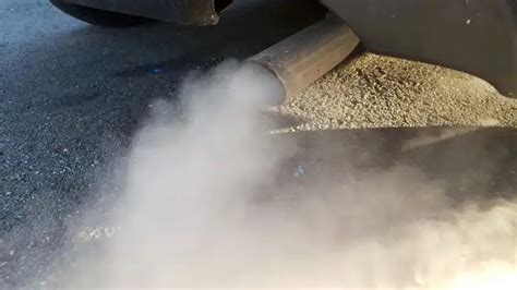 Automobilio išmetamosios dujos su mėlynais/pilkais dūmais