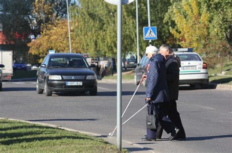 Tematinė nuotrauka su automobiliu sugedusiu kelyje ir atvykusia techninės pagalbos tarnyba