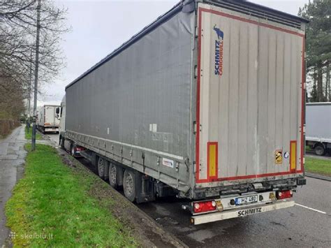 Sunkvežimis su tentine puspriekabe kelyje, rodantis bendrąjį krovinių gabenimo procesą