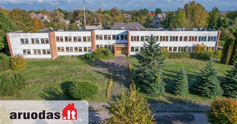 Teminė nuotrauka su moderniu mokyklos pastatu ir iškaba 