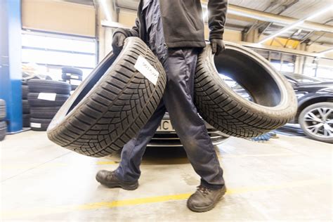 Tematinė nuotrauka su padangų ekspoziciniu stovu automobilių parduotuvėje