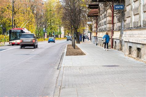 Vilniaus miesto gatvė su intensyviu eismu piko valandomis, atspindinti dinamišką eismo aplinką ir būdingus pastatus