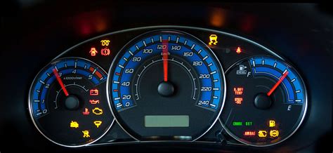 Tematinė nuotrauka su automobilio prietaisų skydeliu, kuriame dega įvairios įspėjamosios lemputės