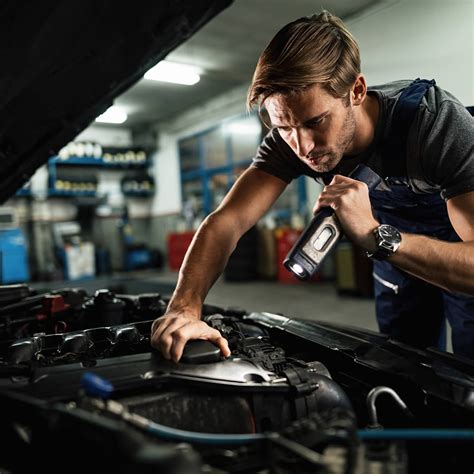 Themafoto: professionelle Automechaniker, die an einem Skoda-Fahrzeug arbeiten, mit einem Computerdiagnosegerät im Vordergrund.