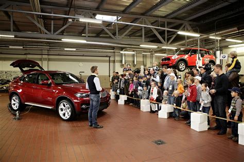Tematinė nuotrauka: Automobilių salonas su išrikiuotais naudotais automobiliais ir aptarnaujančiu personalu