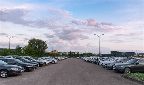 Teminė nuotrauka, vaizduojanti naudotų automobilių turgų Rusijoje su įvairių markių automobiliais ir pirkėjais