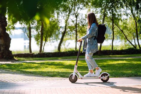 Tematinė nuotrauka: žmogus važiuojantis elektriniu paspirtuku miesto gatvėje