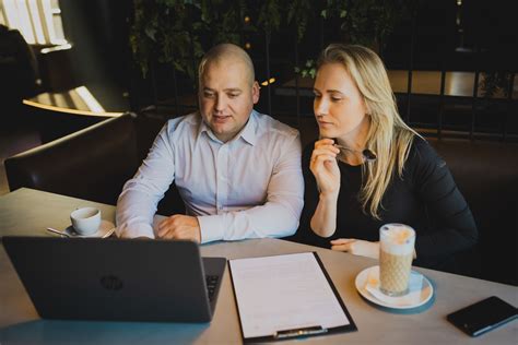 Teminė nuotrauka, vaizduojanti NT brokerį, kalbantį su klientais