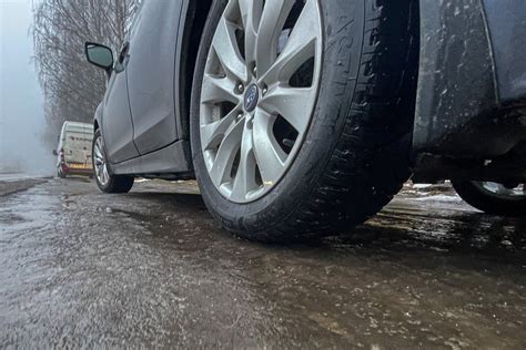 Tematinė nuotrauka: kelias su sniegu ir automobiliu su žieminėmis padangomis