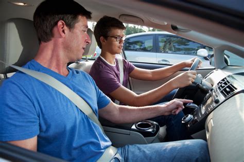 ŠEIMOS narys su moksleiviu automobilyje, mokantis vairuoti