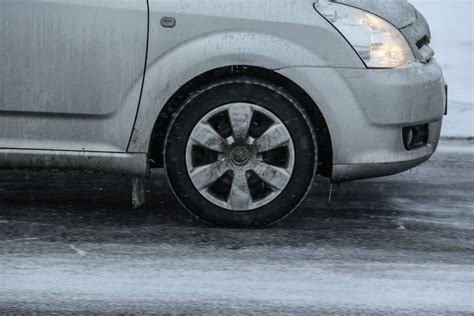 automobilis su dygliuotomis padangomis ant apledėjusio kelio