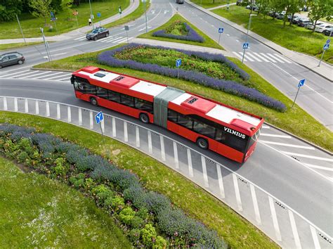 Tematinė nuotrauka: elektromobiliai įkrovimo stotelėje, dviračių takas, modernus viešasis transportas