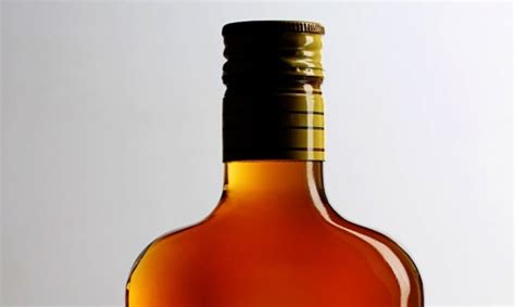 teminė iliustracija: medžioklinis ginklas ir alkoholio butelis