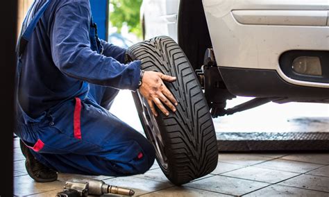 Tematinė nuotrauka: žmogus apžiūri automobilio padangas
