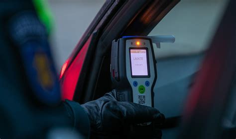 Policijos pareigūnai tikrina neblaivaus vairuotojo girtumą alkotesteriu