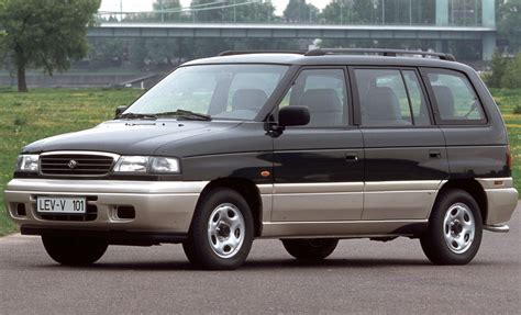 Mazda MPV važiuojanti keliu saulėlydžio metu