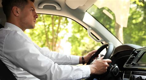 Nuotrauka, vaizduojanti automobilį su už valytuvo įkištu baudos kvitu