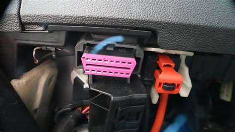 Close-up photo of an OP-COM diagnostic cable connected to an OBD-II port