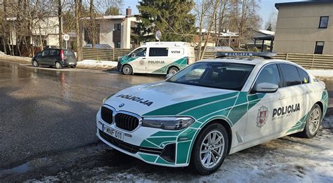 Tematinė nuotrauka: policijos pareigūnai tikrina dokumentus prie sustabdyto automobilio.
