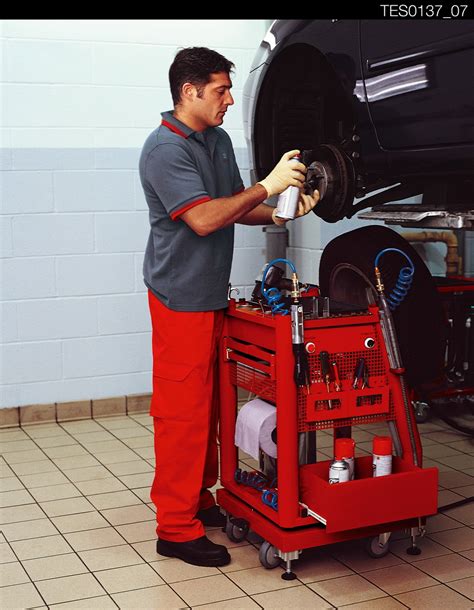Mechanikas keičiantis automobilio amortizatorių servise