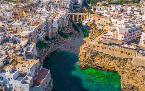 Polignano a Mare paplūdimys su baltais namais ant uolos
