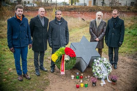 Nuotrauka su uždegtomis žvakėmis ir gėlėmis atminti aukoms