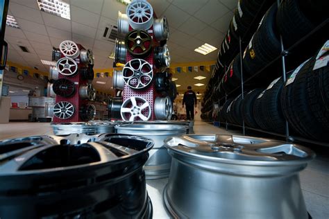 Žmogus apžiūri ratlankius automobilių dalių parduotuvėje
