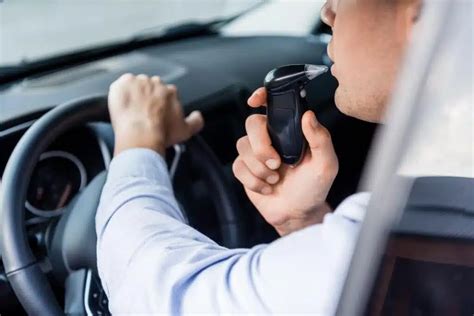 Tematinė nuotrauka: žmogus pučia į alkobloką automobilyje