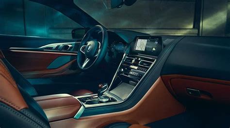 The interior of a modern BMW car with emphasis on the driver-oriented cockpit and high-quality materials.