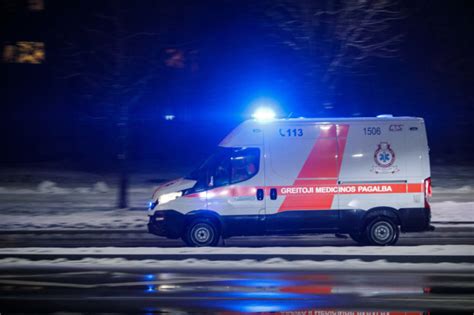 Tematinė nuotrauka su greitosios pagalbos automobiliu kelyje, apsuptame sniego ar purvo