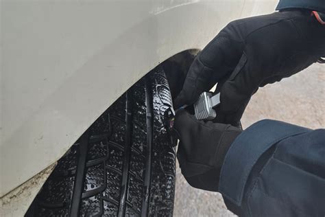 Motociklininkas tikrina motociklo padangų protektoriaus gylį