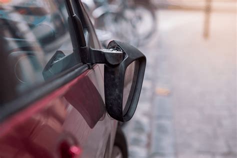 Tematinė nuotrauka: žmogus klijuoja automobilio veidrodėlį dvipuse juosta