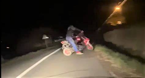 Nuotrauka, vaizduojanti paauglį, važiuojantį mopedu su šalmu