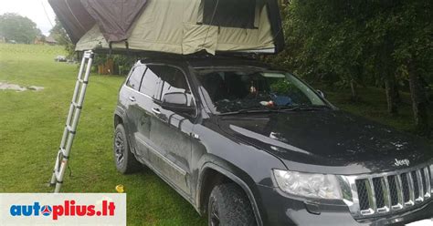 Šeima stovyklaujanti su automobiliu ir stogo palapine