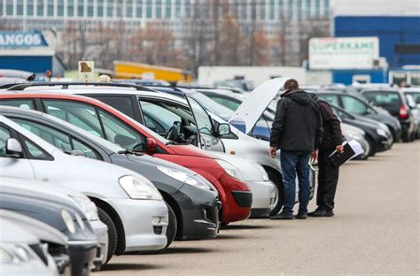 Teminė nuotrauka: žmogus apžiūri naudotą automobilį automobilių salone
