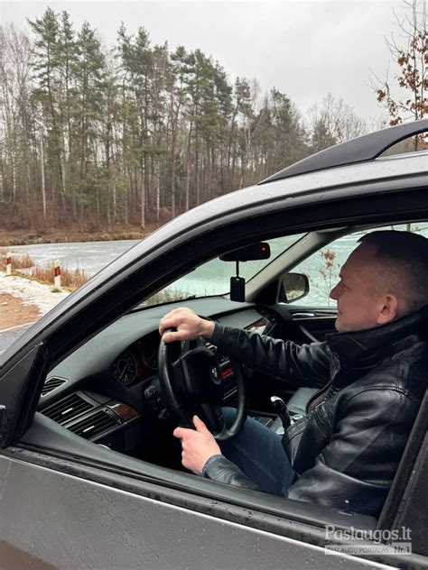 Tematinė nuotrauka: vairuotojas, sėdintis lengvajame automobilyje, paruoštas darbui