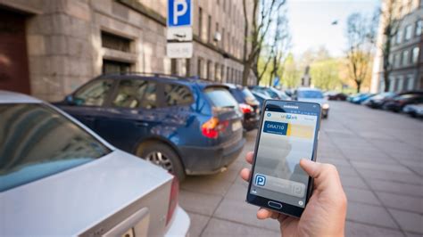 Tematinė nuotrauka: žmogus naudojasi išmaniąja parkavimo programėle