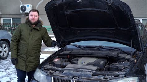Vaizdinis variantas: vyras apžiūrinėja automobilio variklį servise