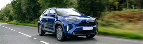 Toyota Yaris Cross Hybrid automobilis dinamiškame miesto fone