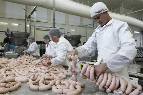 Tematinė nuotrauka: mėsos fabrikas su darbuotojais ir autokrautuvais