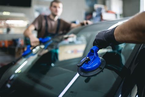 specializuotas stiklų keitimo servisas: technikas montuoja naują automobilio stiklą