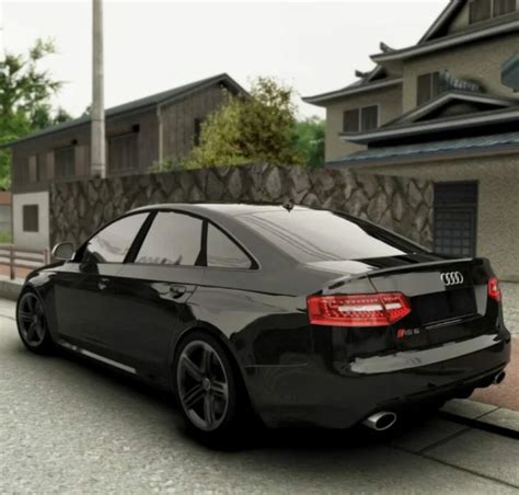 The Audi A6 C6 parked on a street with a blurred city background. The focus is on the car and its sleek design.