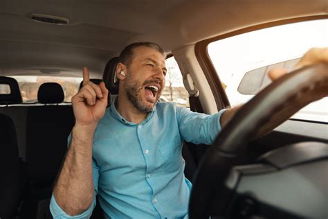 Teminė nuotrauka: žmogus vairuoja automobilį su pritvirtintu telefonu laikiklyje