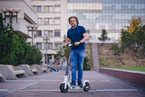 Teminė nuotrauka: žmogus važiuojantis elektriniu paspirtuku mieste