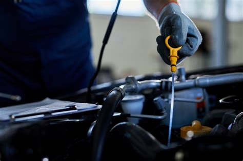 Mechanikas, atliekantis tepalų keitimą automobilyje