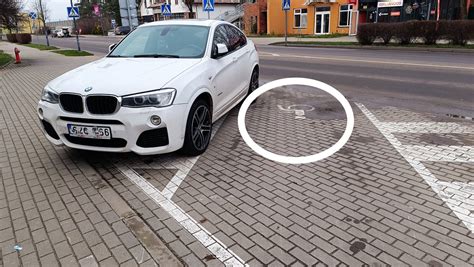 Teminis paveikslėlis: automobilis parkavimo vietoje su neįgaliojo simboliu