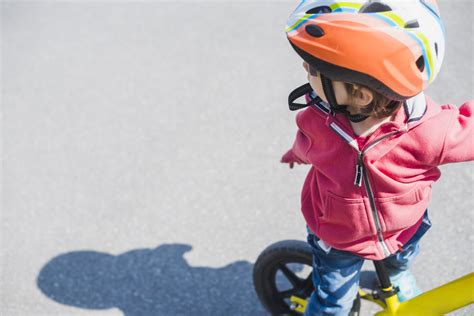 Motociklininkas su vaiku ant motorolerio, dėvintys šalmus