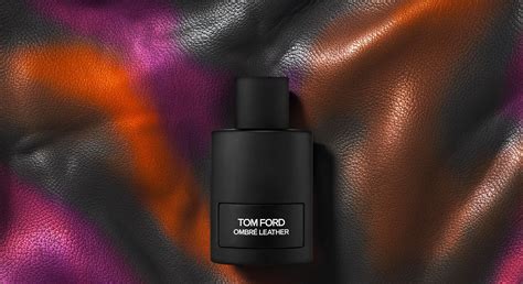 Mados dizainerio Tom Ford portretas šalia prabangių kvepalų buteliukų