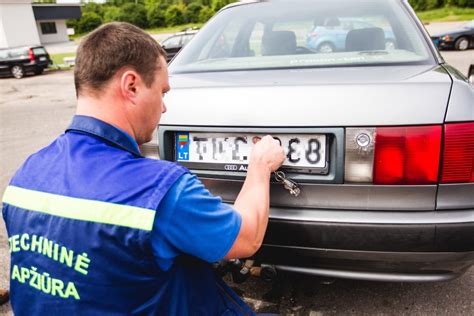 Tematinė nuotrauka: žmogus, naudojantis telefoną automobilio patikrai pagal numerį